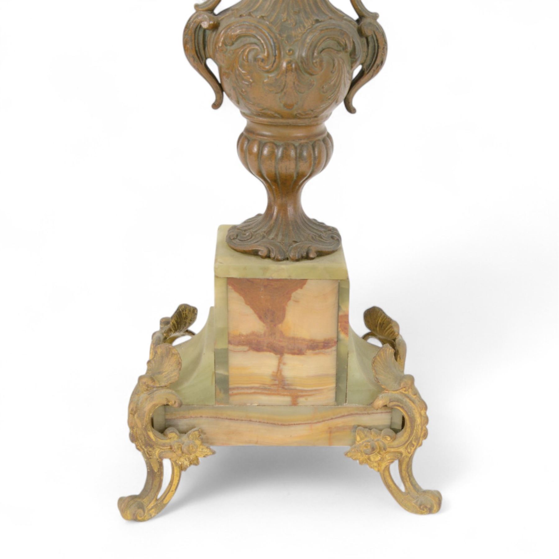 French-Edwardian green onyx clock garniture with a shaped case surmounted by a cast patinated figure of  a maiden in 18th century dress, with gilded scroll feet and conforming mounts, porcelain dial with Arabic numerals and floral decoration, twin train rack striking movement sounding the hours and half-hours on a bell, with a matching pair of five light candelabra. With pendulum.    