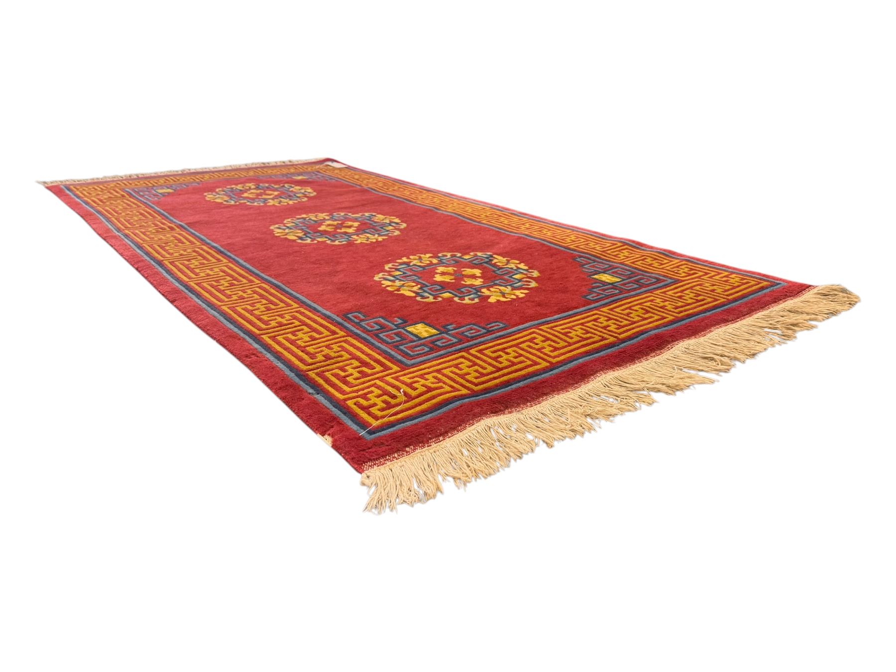 Tibetan-design handwoven rug, deep red field with three central medallions in yellow and blue, traditional yellow key border, white fringes on both ends
