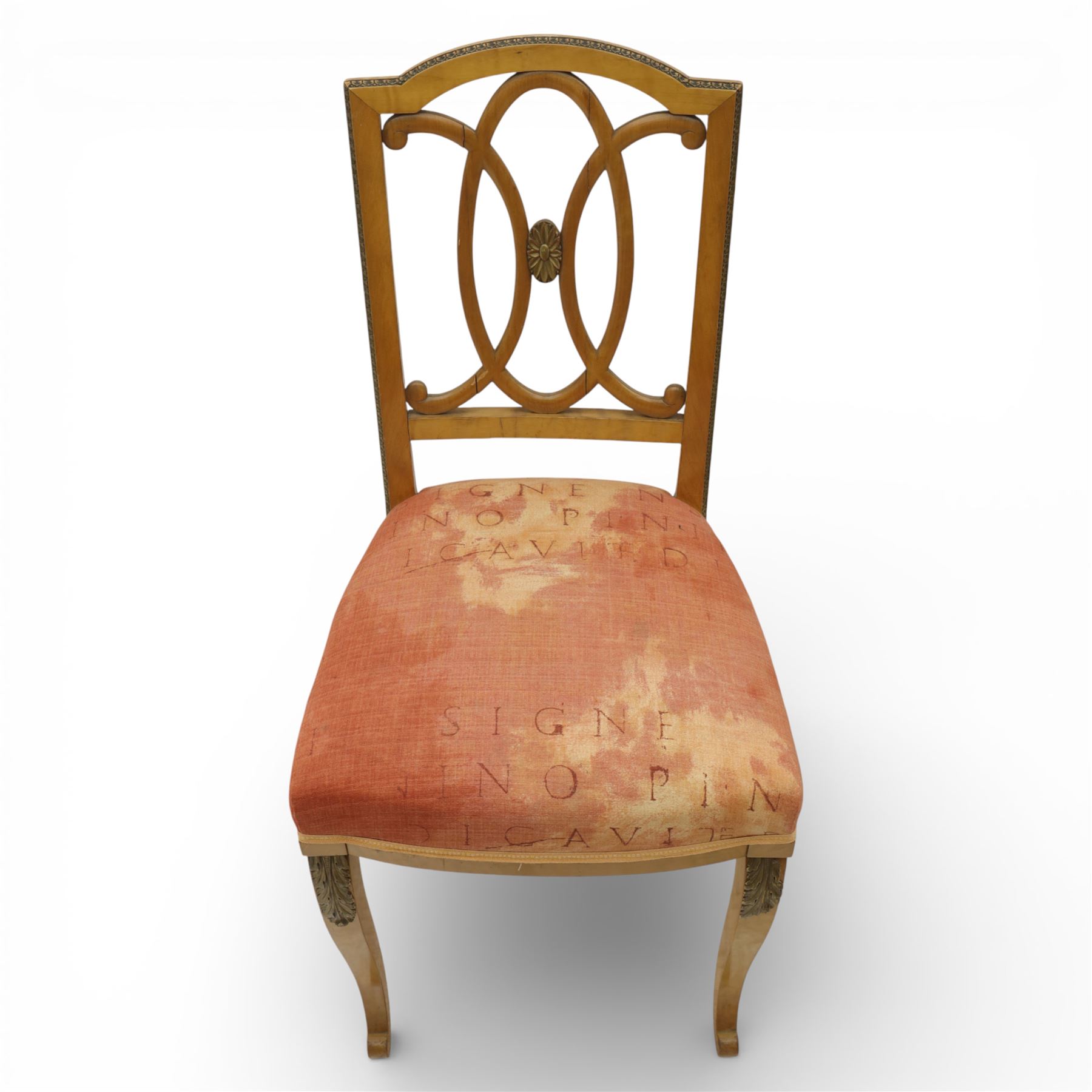 Edwardian pair of satinwood side chairs, each with shaped crest rail above an intertwining oval pierced splats centred by a floral patera, upholstered drop-in seats, raised on cabriole supports with applied floral mounts to the knees