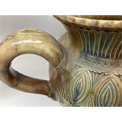 Early 20th century Royal Doulton stoneware vase, decorated with a stylized floral design below a wavy rim, monogrammed B.N, possibly for Bessie Newbery, H28cm, together with an early 20th century glazed jug, heavily carved throughout (2)
