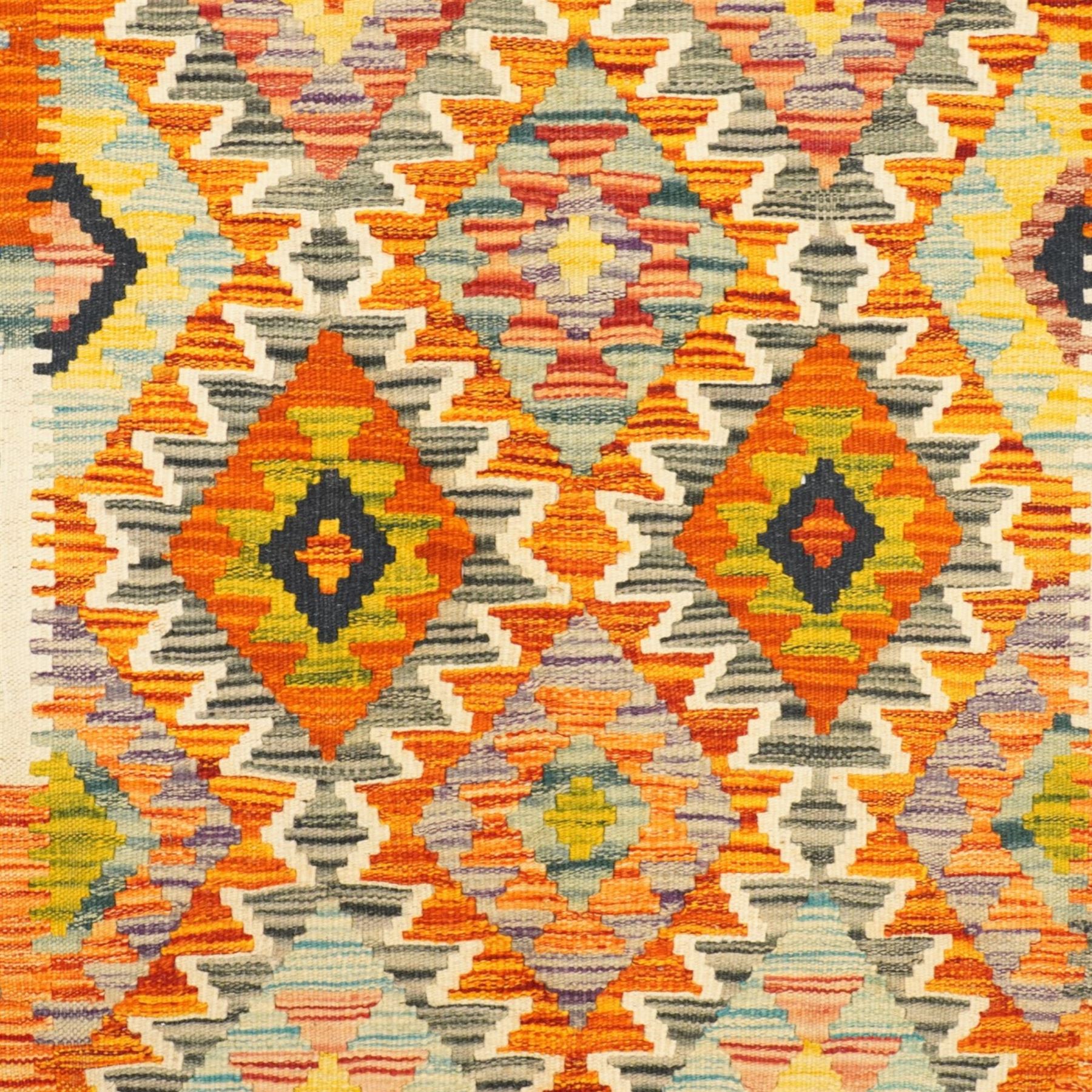 Afghan Chobi flatweave kilim and an Afghan Chobi flatweave kilim runner, with a repeating stepped diamond medallion design in ivory, green, rust, teal, purple, and indigo, framed by chevron and geometric borders, 148x53cm & 129x80cm, (2)