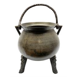 17th century bronze cauldron, probably German or Austrian, of bellied form with twin angular handles supporting a twisted handle, upon three splayed zoomorphic bearded mask feet, not including handle H30cm, rim D22cm