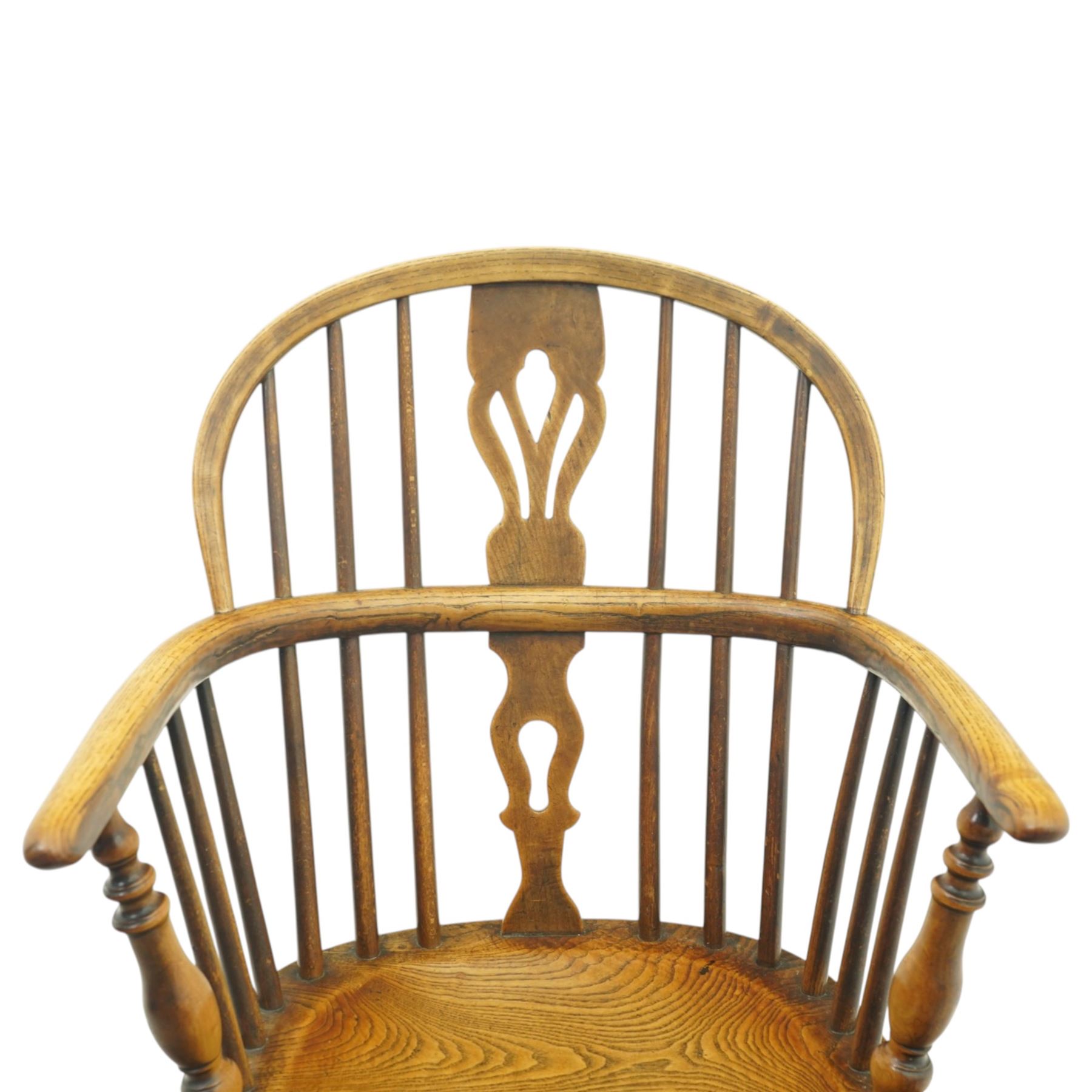 19th century low back elm Windsor armchair, hooped back with pierced central splat and radiating spindles, shaped arm bow over saddle seat, on turned supports united by crinoline stretcher