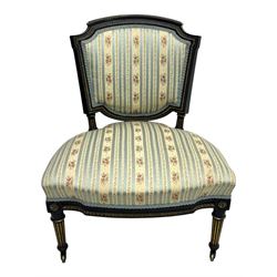 19th century French ebonised low chair, upholstered in floral striped fabric within a moulded frame with gilt line and foliate decoration, the seat of serpentine form, raised on turned fluted legs with toupie feet
