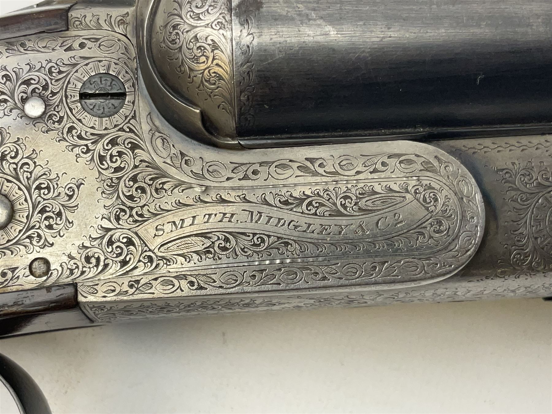 Smith Midgley Bradford 12-bore side-by-side double barrel side-lock ejector shotgun with 71cm barrels, engraved action with patented top lever, ivy leaf fences and top safety, walnut stock with chequered grip and fore-end, serial no.62409 to barrels and 1481 to action, L115cm overall SHOTGUN CERTIFICATE REQUIRED