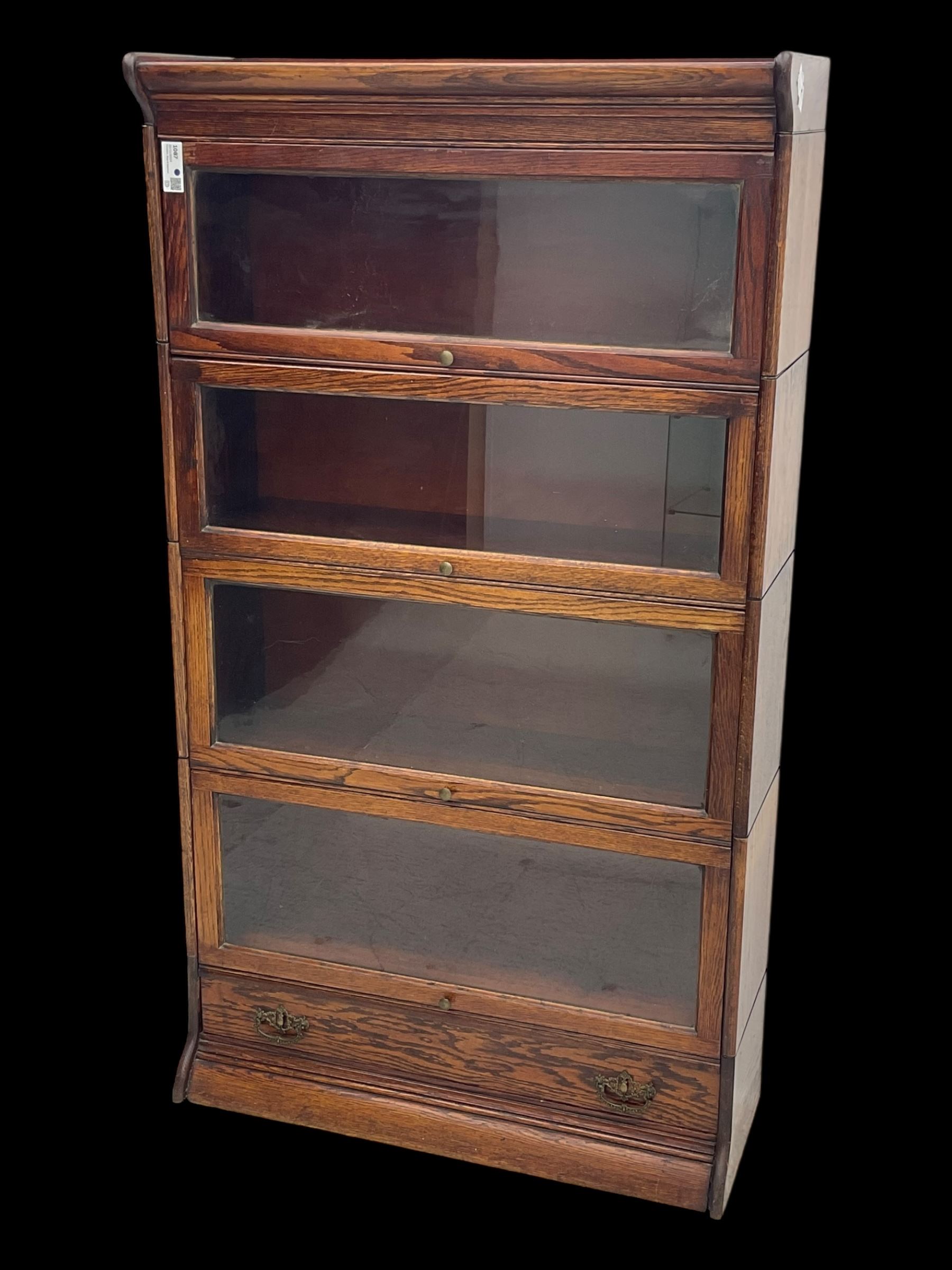 Early 20th century oak stacking library bookcase, four sections enclosed by hinged and sliding glazed doors, fitted with single drawer 