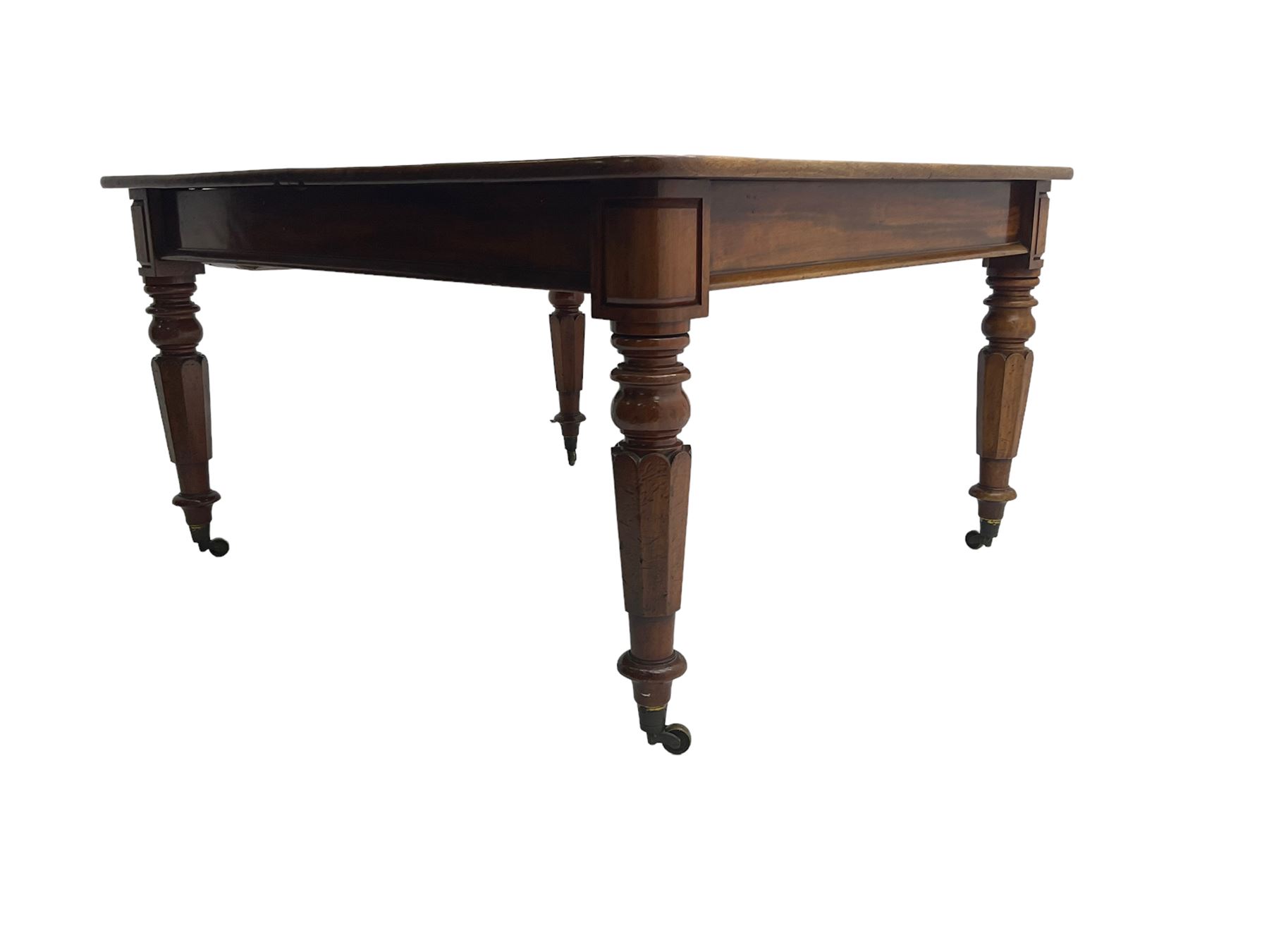Late 19th century extending mahogany dining table, square top with banded frieze rail, raised on turned octagonal supports with  brass cups and castors, with two additional leaves