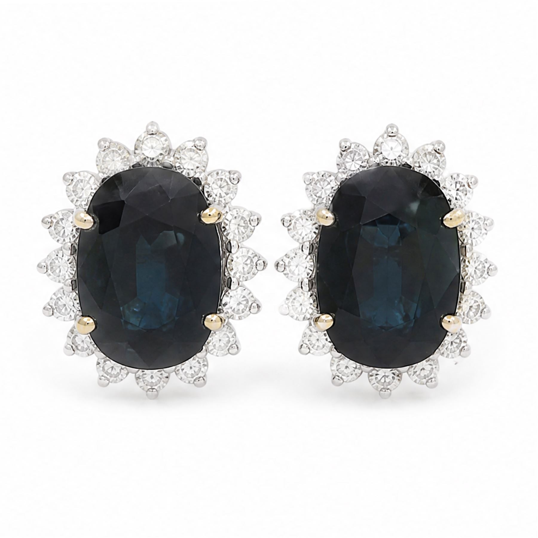 Pair of 18ct white gold sapphire and diamond cluster earrings, each stud set with a single oval cut sapphire, surrounded by sixteen round brilliant cut diamonds, total sapphire weight approx 6.65 carat, total diamond weight approx 1.00 carat