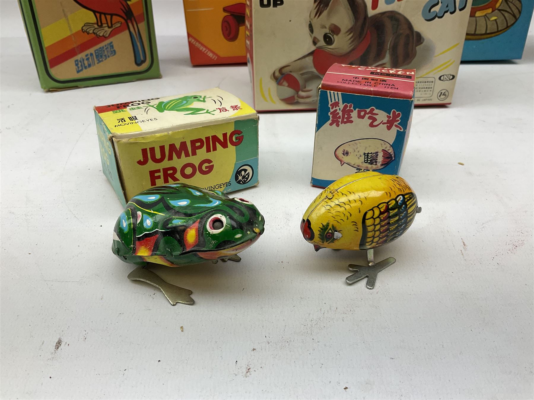 Seven modern Chinese, Japanese and Continental boxed tin-plate toys including Ucan Daire Flying Saucer, Drumming Animal, Circus Clown, Puzzle Cat, Bird with Jumping Action etc; and a quantity of clockwork toy keys (7)