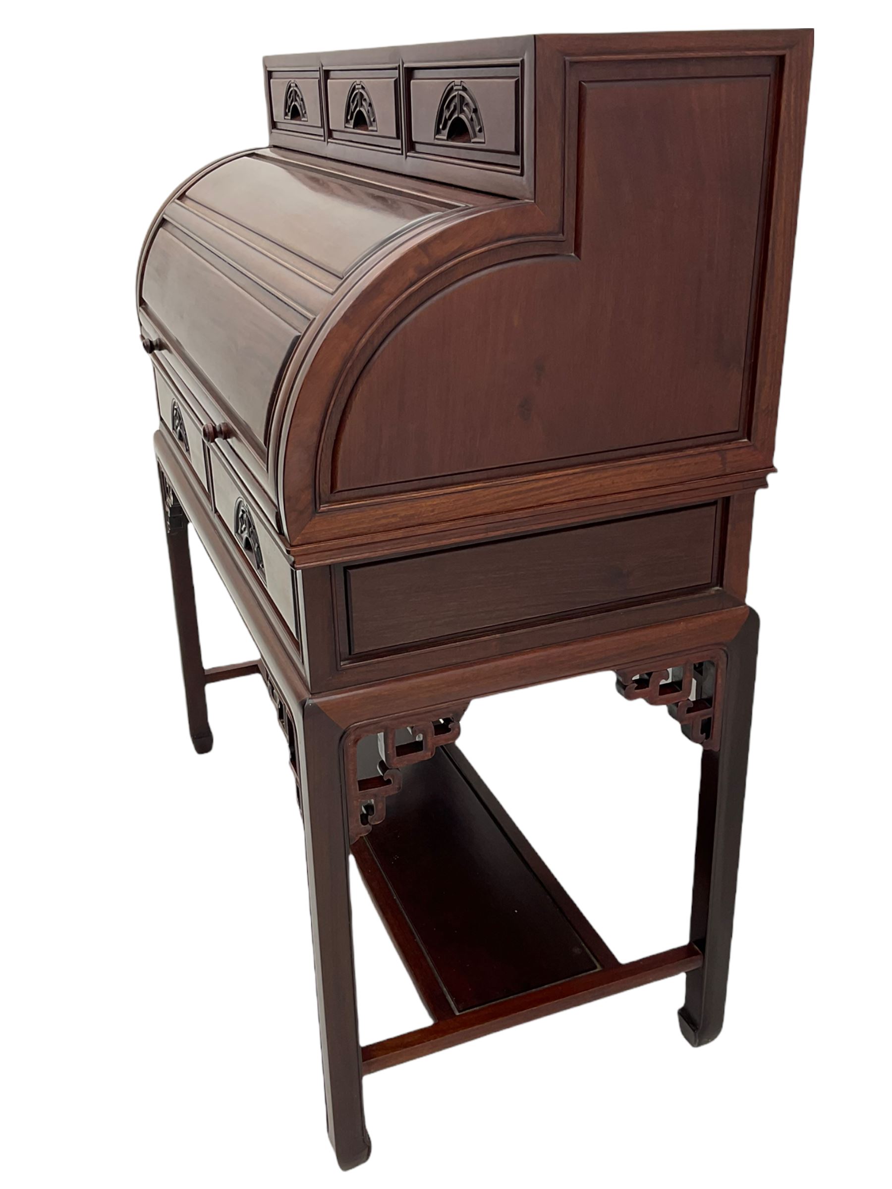 Hardwood cylinder desk, three drawers raised over curved lid, fitted interior with slide, the supports joined by undertier with fret work brackets 