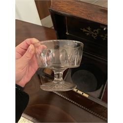 Early 19th century rosewood and brass inlaid tea caddy, of sarcophagus form, the front and hinged opening cover inlaid with brass scrolling panels, opening to reveal a compartmented interior with twin removable boxes with conforming inlaid brass detail to the hinged covers and zinc lining to the interiors, flanking a later glass mixing bowl, the whole upon four turned cylindrical feet, H21cm W36cm D20cm