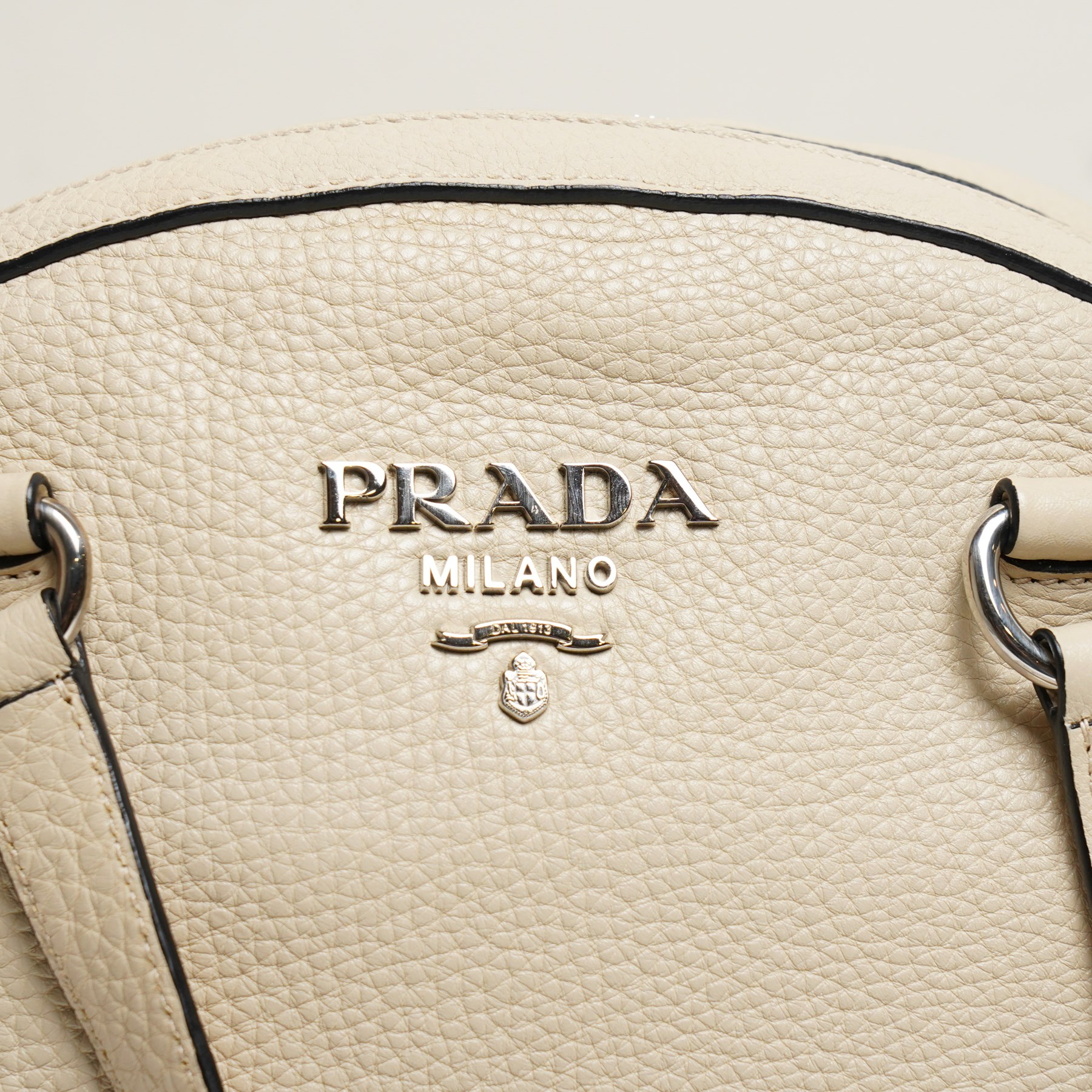 Prada - Bauletto handbag in Quarzo Vitello Daino pebbled calf leather with black piping, with twin leather top handles, silver-tone Prada Milano logo and hardware, zip top fastening, detachable and adjustable shoulder strap and leather clochette, with authenticity cards and original Prada dust bag
