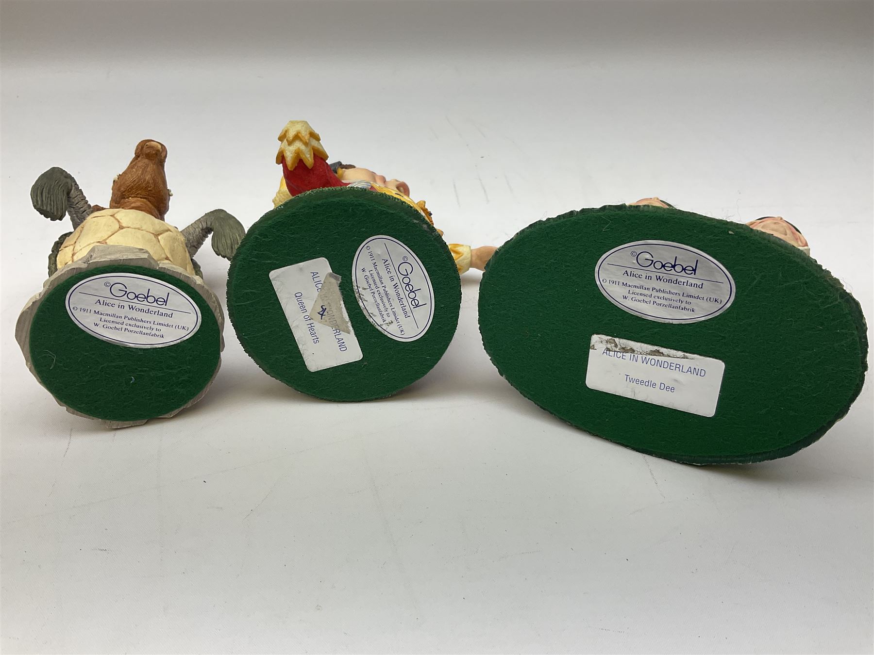 Goebel Alice in Wonderland figures, comprising Alice and Cat, White Rabbit, Queen of Hearts, March Hare, Tweedle Dee and the Mock Turtle, largest H18cm