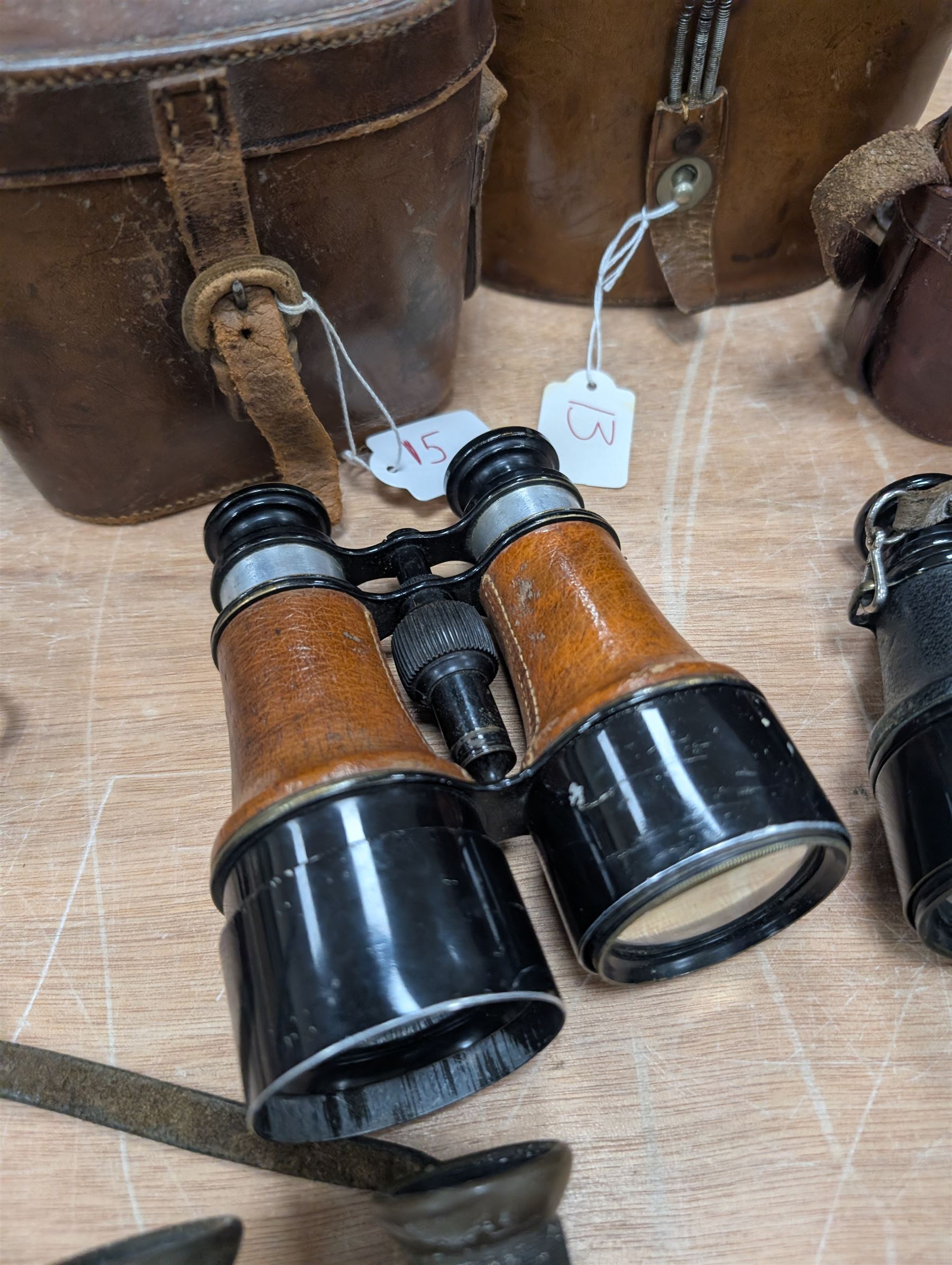 Four pairs of early 20th century binoculars, including Carl Zeiss Jena Feldstecher binoculars, Carl Zeiss Telact 8x binoculars, Dollond x5 field binolculars and one other pair, all in leather cases, one case marked with broad arrow, some with officers name etched