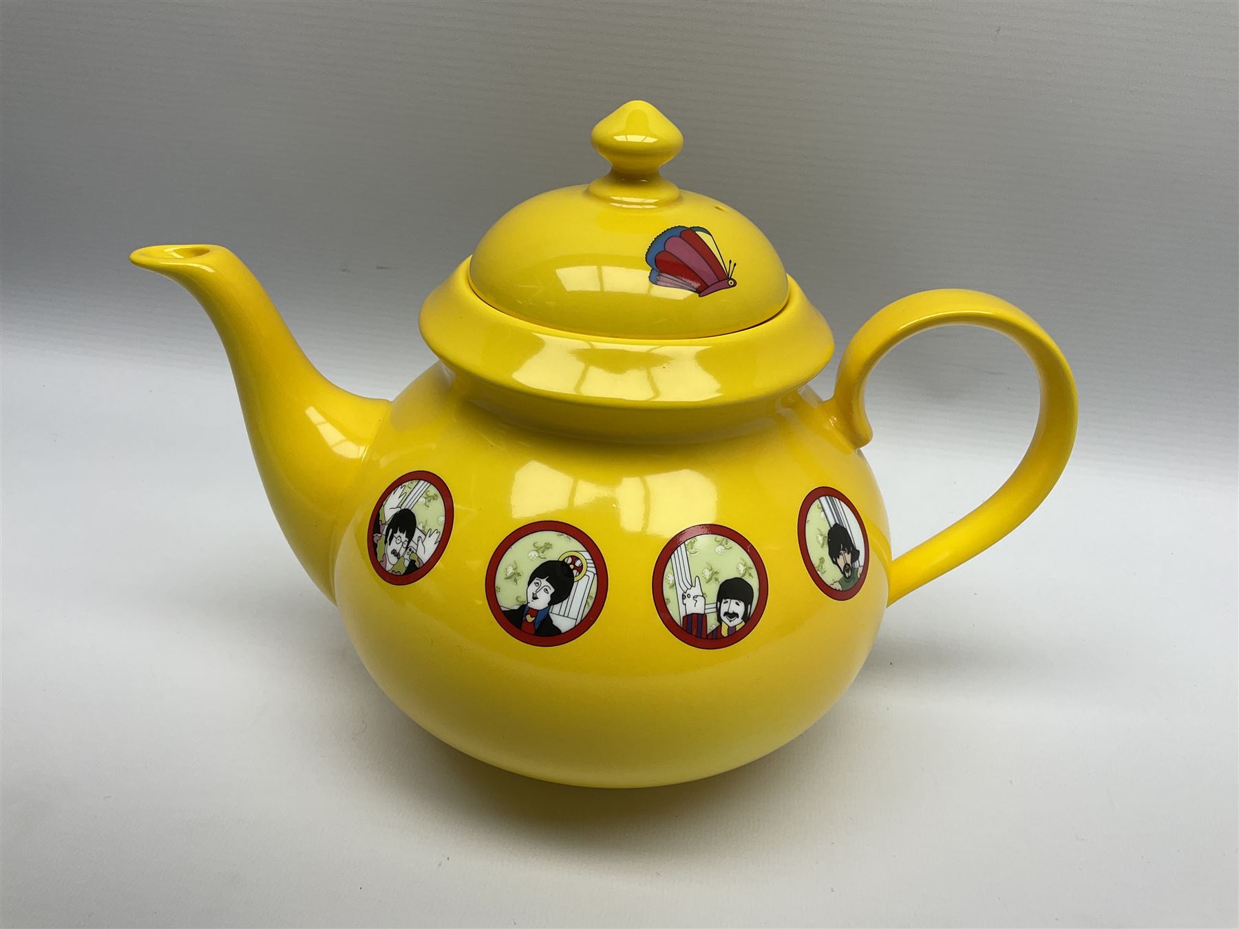 Limited edition Beatles Yellow Submarine teapot, designed by Paul Smith and made for Thomas Goode, 4/200, together with matching egg cups, 25/200, both in original boxes. 