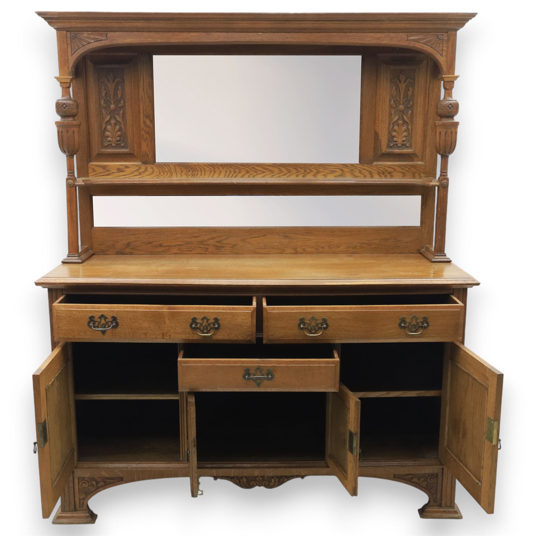 Arts and Crafts oak mirror back sideboard, the bevelled rectangular mirror set within a back with foliate carved panels, with turned baluster and knopped supports, upon a base with moulded top above three drawers  and three cupboard doors, two with carved foliate detail, upon four shaped bracket feet