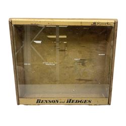 Benson and Hedges countertop glazed display cabinet, the glass hinged lid with white labelling of various cigarettes and cigars, the gilded metal bands with black lettering, W38cm D33cm H8cm