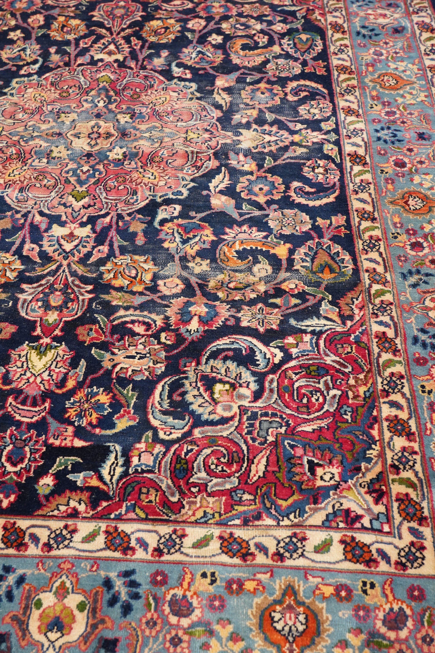 Vintage Persian Tabriz indigo ground rug, the central floral medallion within a field woven with scrolling palmettes and plant motifs, with contrasting spandrels, the the cyan guard lines with scrolling floral patterns