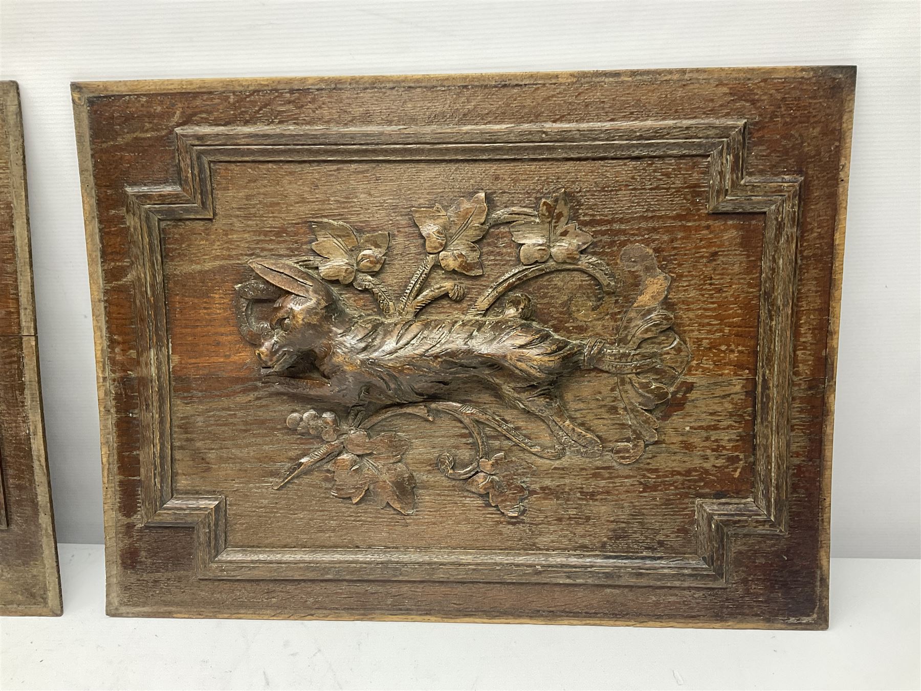 Pair of oak furniture door panels, carved in relief with a fox to one and a hound to the other, together with a pair of smaller oak panels, carved in relief with a hare to one and a grouse to the other, doors W63.cm x H62cm, panels W43cm x H60cm