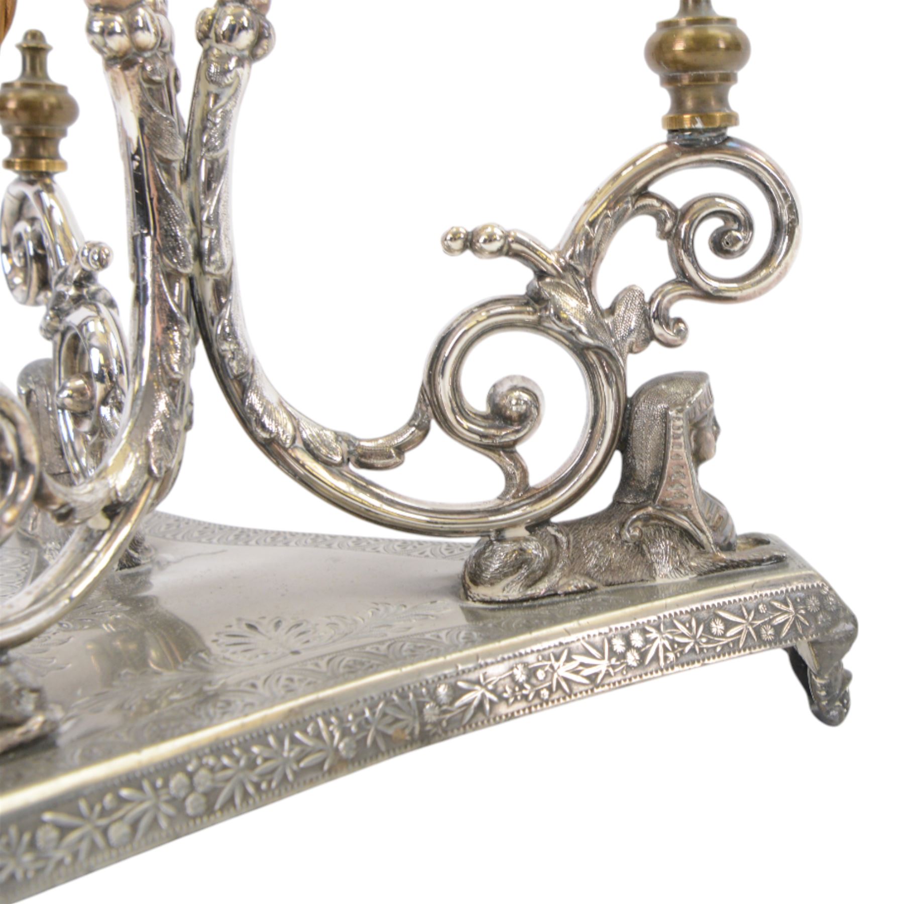 Silver plated Egyptian Revival lamp, with scrolling columns, on a trefoil base, surmounted by three sphinxes, with mask feet, H60cm