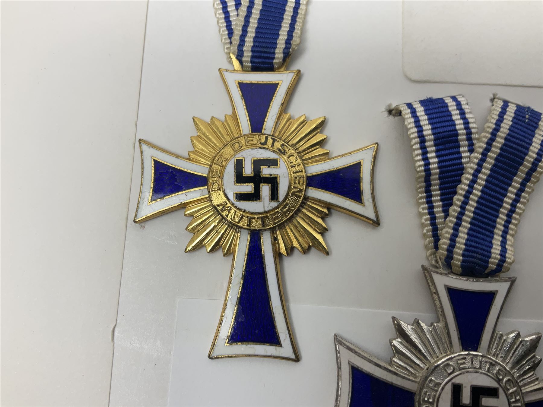 WWII set of three German Mother's Crosses, 1st Class in gilt, 2nd Class in silver and 3rd Class in bronze; all with ribbons (3)