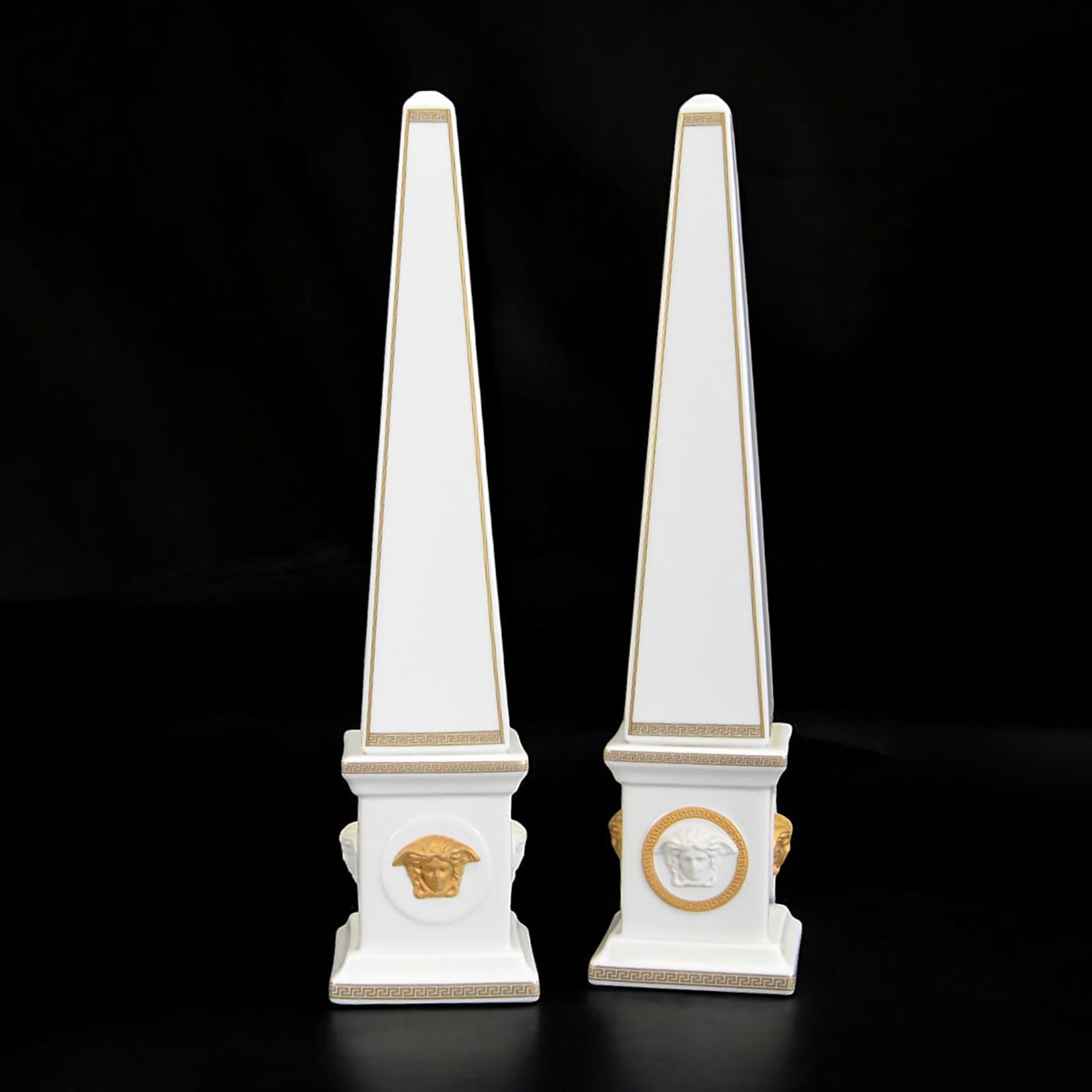 Pair of Rosenthal Versace Gorgona obelisks, each with relief moulded Medusa masks and gilt Greek key borders upon a white ground, both boxed, H38cm