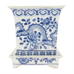 Chinese blue and white planter and stand, each of square slightly tapering and flared form, the planter decorated with two dragons and blossoming peonies, between stylised borders, the stand decorated with flower heads and vines, planter H30cm W29cm, stand H7cm D28.5cm