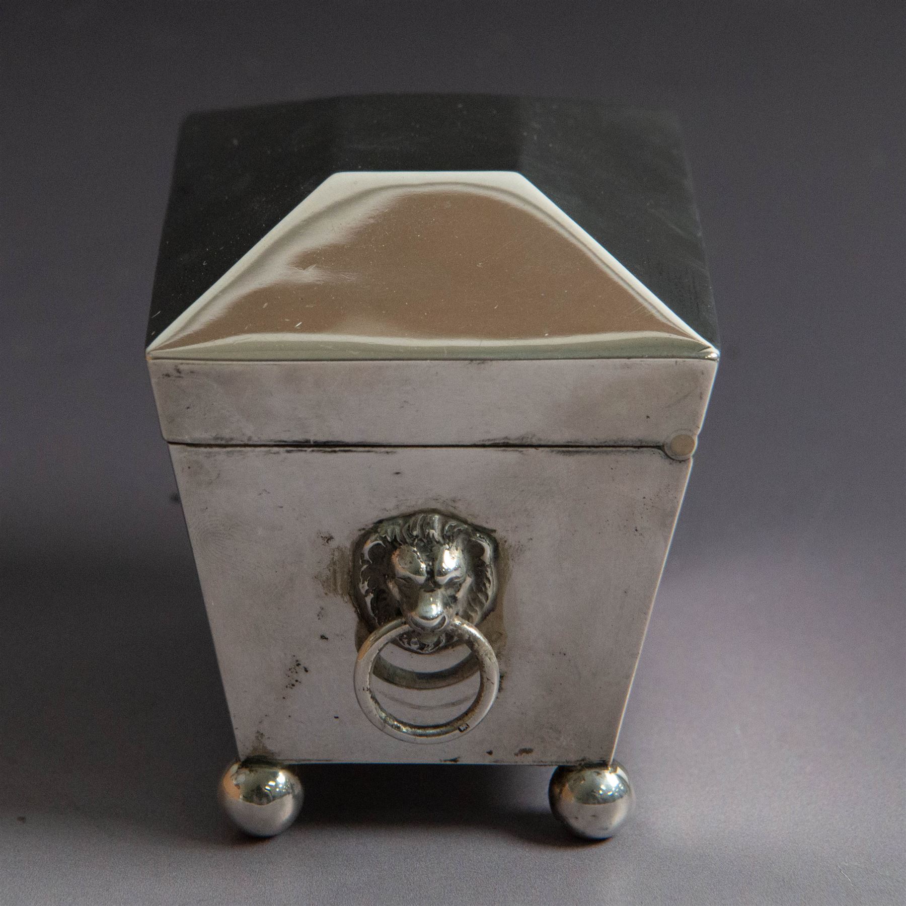 Early 20th century silver tea caddy, of sarcophagus form with twin lion mask mounted loop handles, upon four bun feet, hallmarked William Hutton & Sons Ltd, Birmingham 1913, H8cm, W9cm