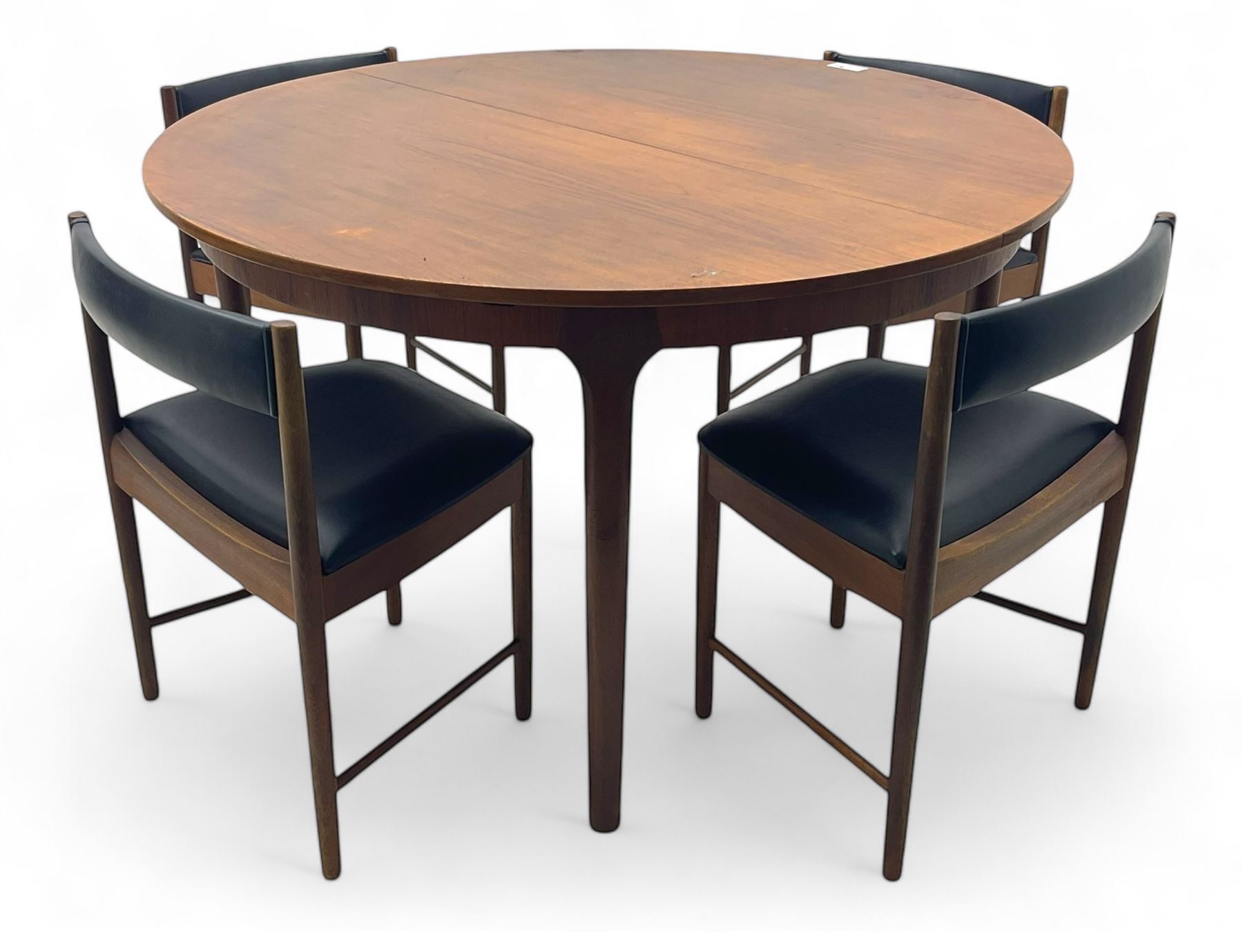 Mid-20th century teak extending dining table, circular top with pull-out extension and concealed leaf extension mechanism, on tapered supports; set of four teak dining chairs with black vinyl padded seats 