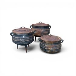 Three South African cast iron graduating cooking pots with lids and handles. Size shown fo...