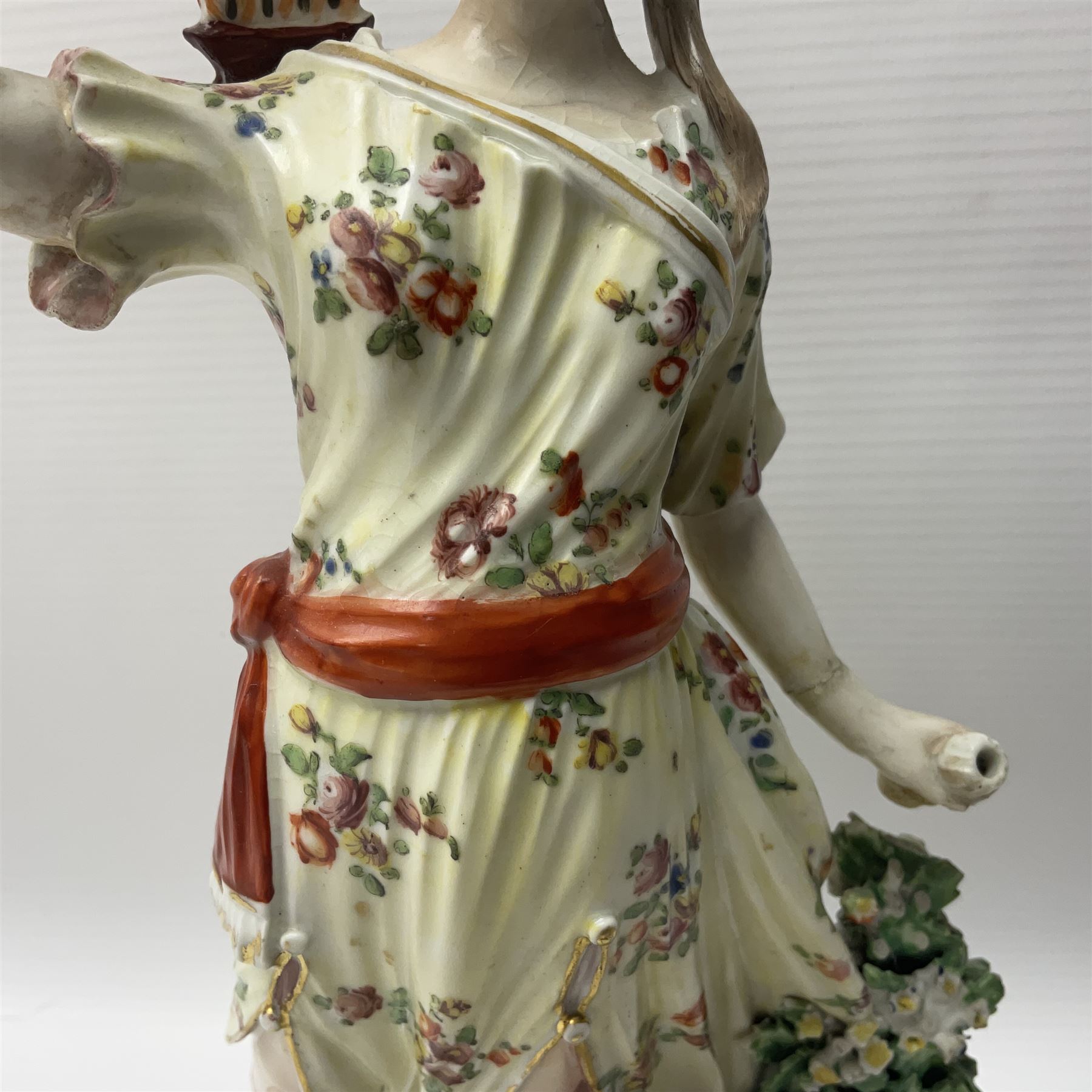 18th century Derby figure of Diana the huntress, circa 1760, modelled reaching for an arrow from quiver across her back, with recumbent hound at her feet, upon a scrolled base with bocage detail, H27.5cm