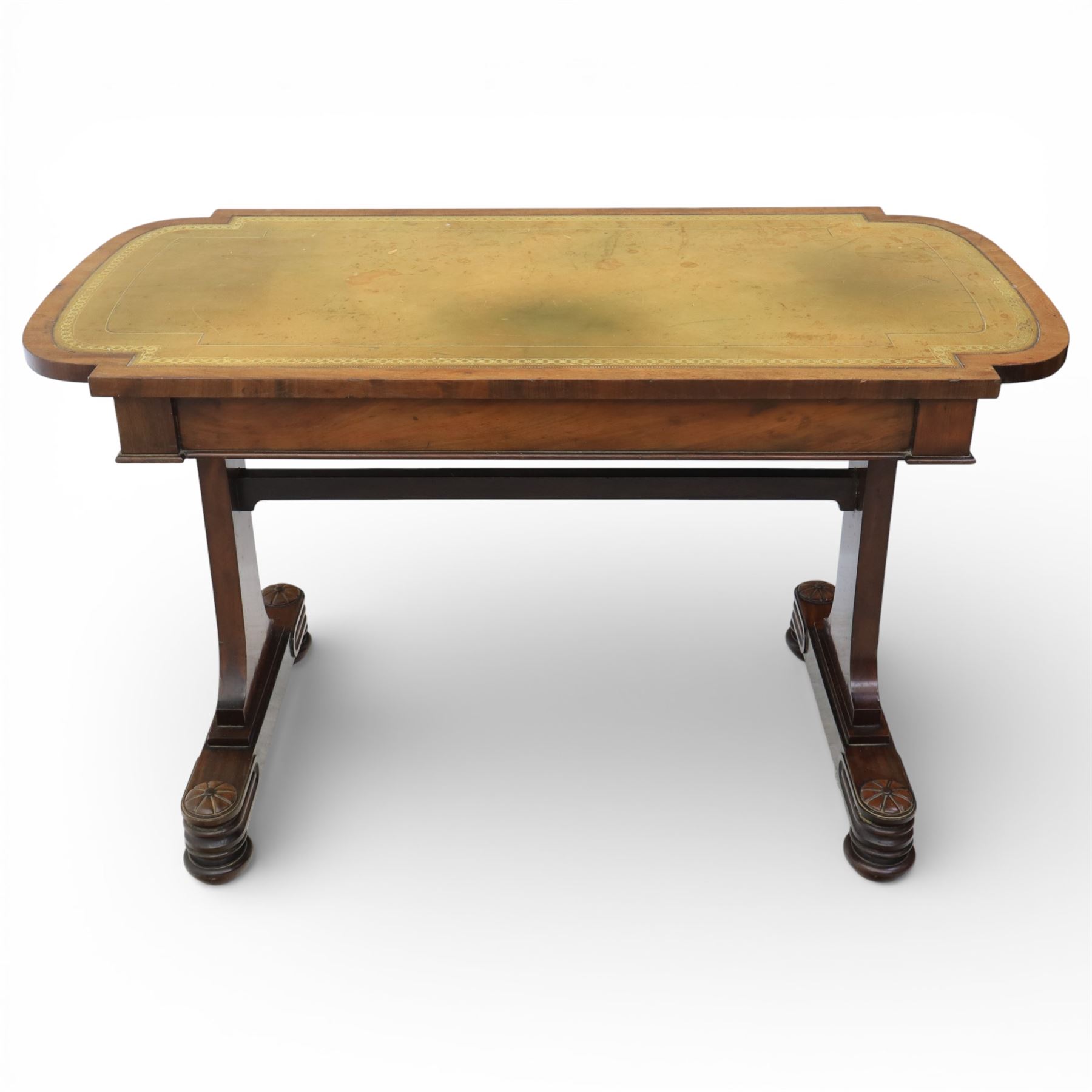 William IV mahogany library table, rectangular top with rounded edges inset with gilt and blind tooled leather writing surface, fitted with opposing frieze drawers, raised upon shaped trestle end supports united by a central upper stretcher, terminating in stylised bun feet with applied roundel bosses