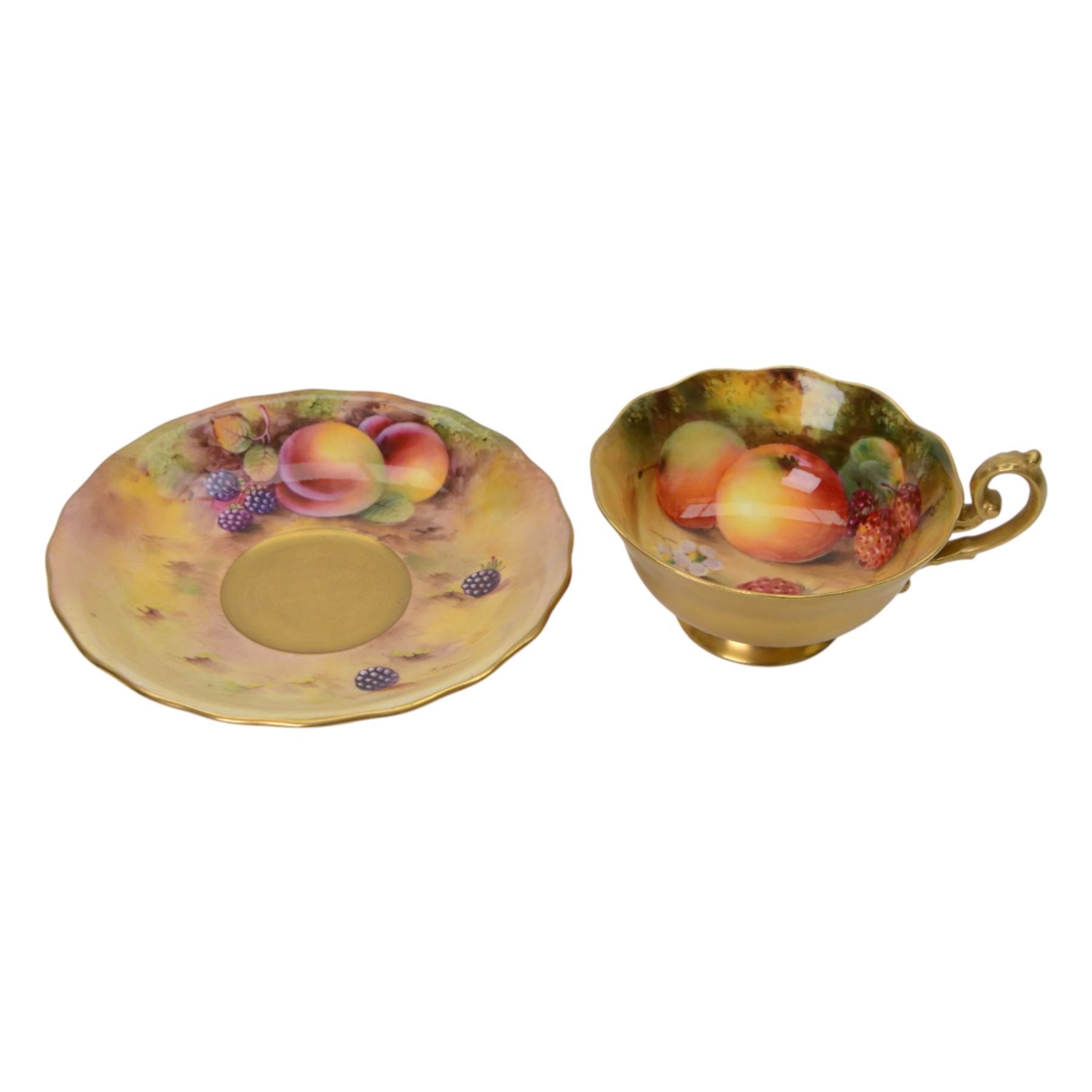Royal Worcester fruit painted cabinet teacup and saucer, interior hand painted with apples, blackberry and cherries upon a mossy ground, the cup exterior and centre of saucer gilded, cup and saucer signed Rickells, each with puce coloured printed marks beneath, H7cm