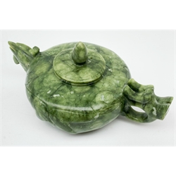 A carved jade teapot, the spout modelled as the head of a bird, the handle modelled as a stylised dragons head, H7.5cm. 