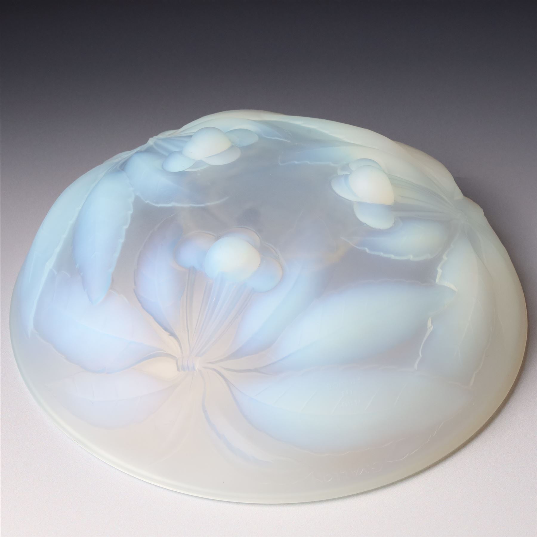 G Vallon, a French opalescent glass bowl decorated with a raised pattern of cherries and leaves signed G Vallon D23cm