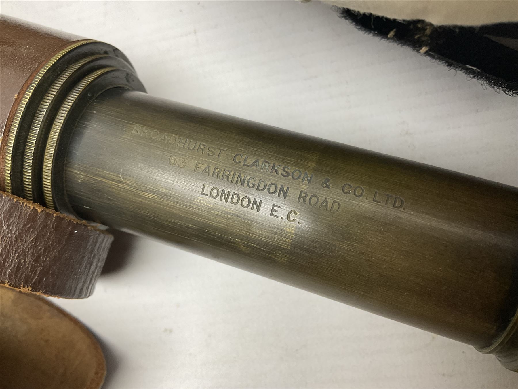 Broadhurst Clarkson brass and leather 4-draw telescope, the first draw with graduations, sliding lens shroud and leather covers for both ends on shoulder strap; marked 'Broadhurst Clarkson & Co. Ltd. 63 Farringdon Road London E.C.', L87cm fully extended; together with a WWI brass marching compass marked F-L No.123113 1918 (broad arrow); crudely etched L.H. McD. Latham; in associated Brooks & Co. leather case dated 1913 stamped W.B. Constable (2)