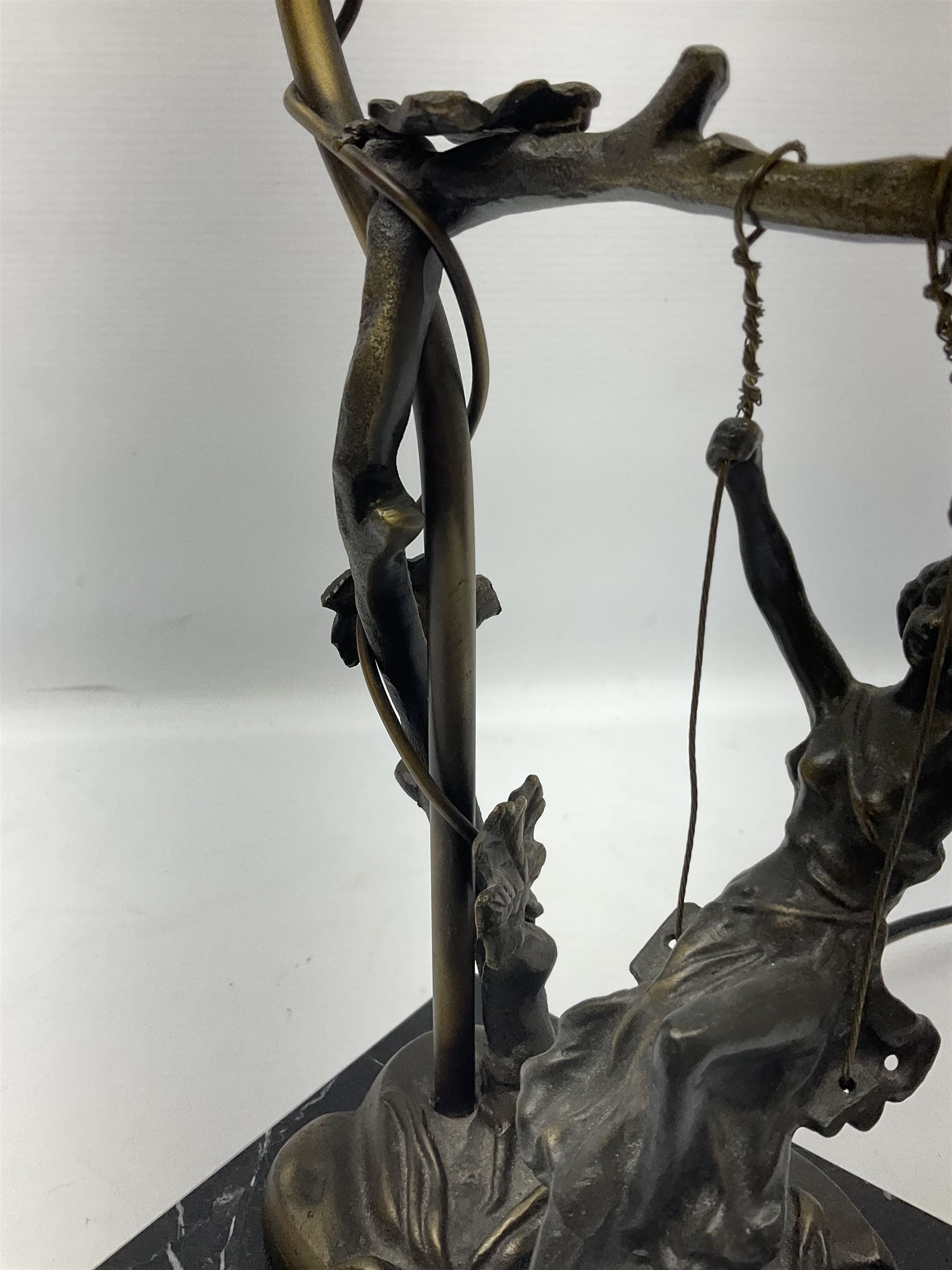 Art Nouveau style lamp in the form of a woman on a swing, with a green mottled shade, upon a marble base H52cm