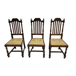 Set five early 20th century oak dining chairs, the shaped cresting rail carved with scrolls, upholstered drop in seats, on turned supports joined by H-stretchers