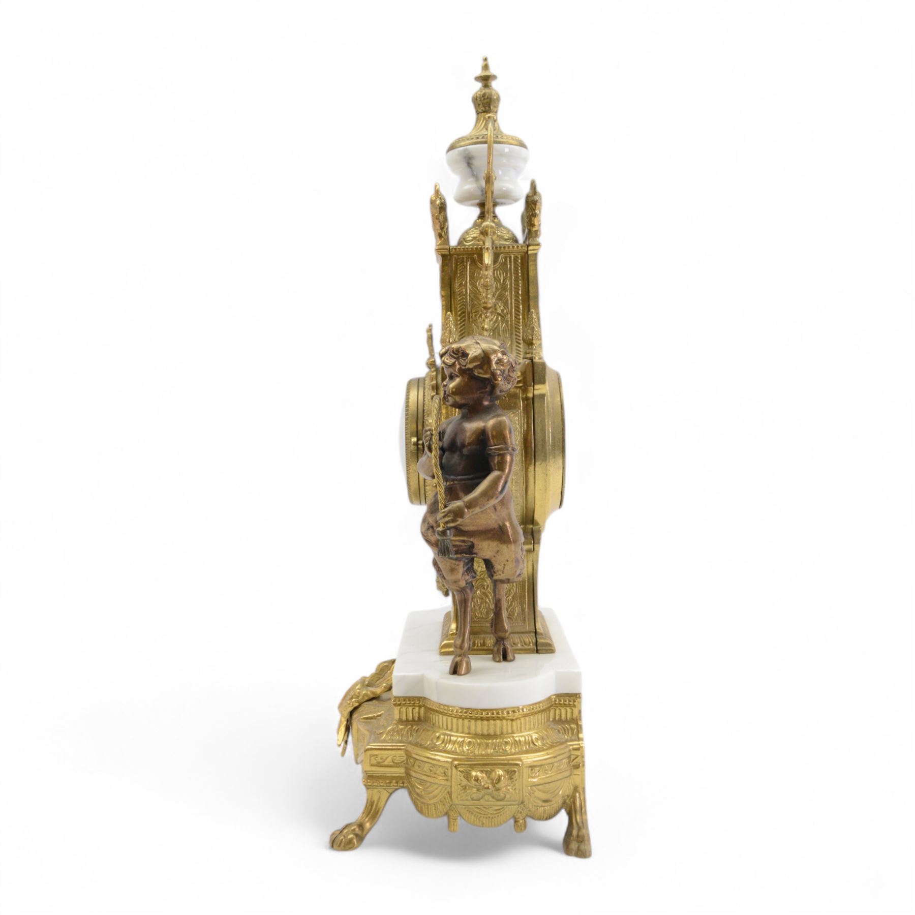 Italian- 20th century 8-day gilt figural mantle clock in the style of a 19th century Parisian lyre clock, drum movement with a porcelain dial flanked by playful cloven-hoofed cherubs on a white marble plinth, raised on a a decorative base with splayed paw feet, twin train spring driven Hermle movement with a floating balance escapement, sounding the hours and half hours on two bells. With key.    