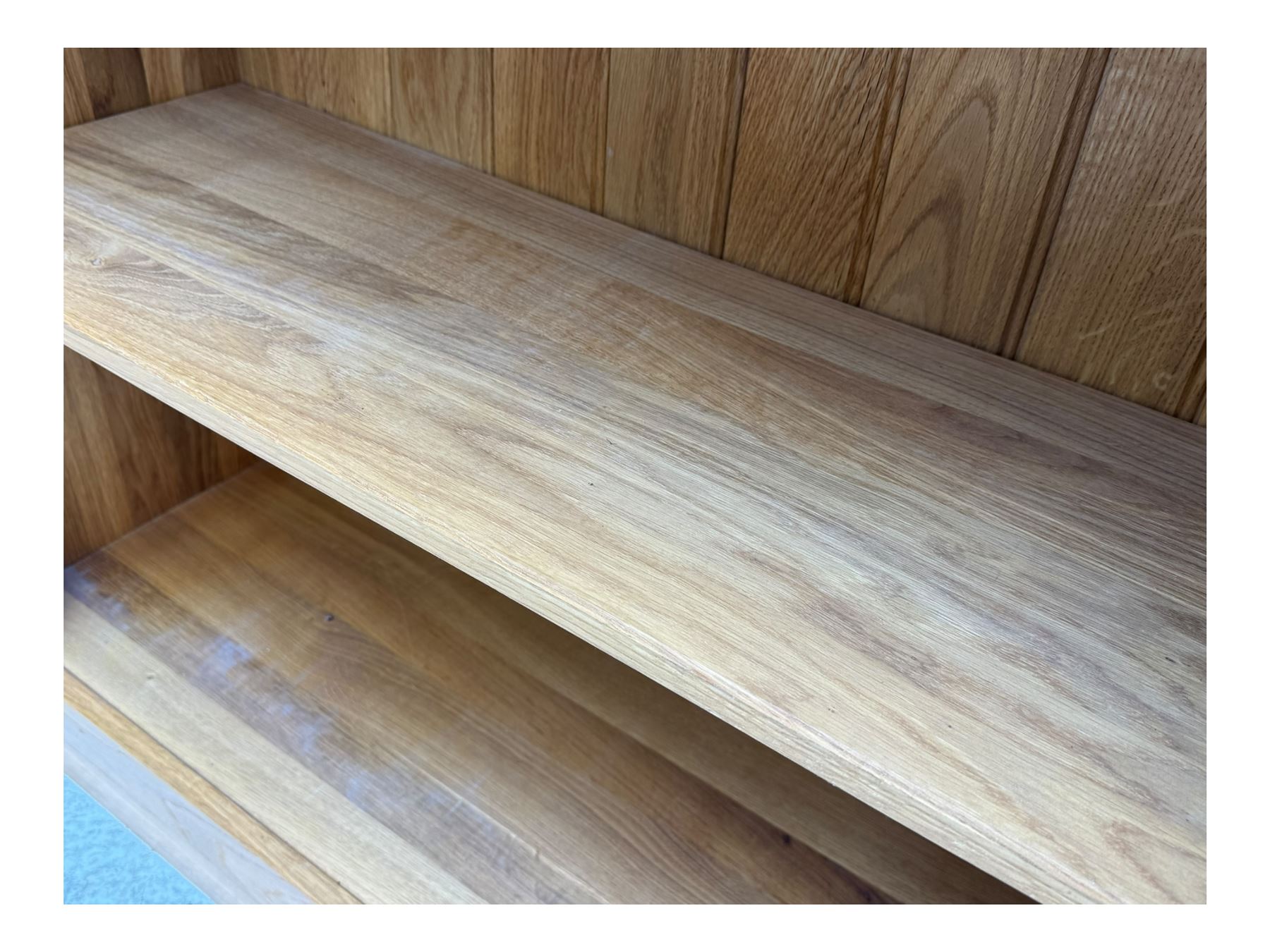 Contemporary light oak open bookcase, rectangular form with projecting top, fitted with five adjustable shelves, on a straight plinth base