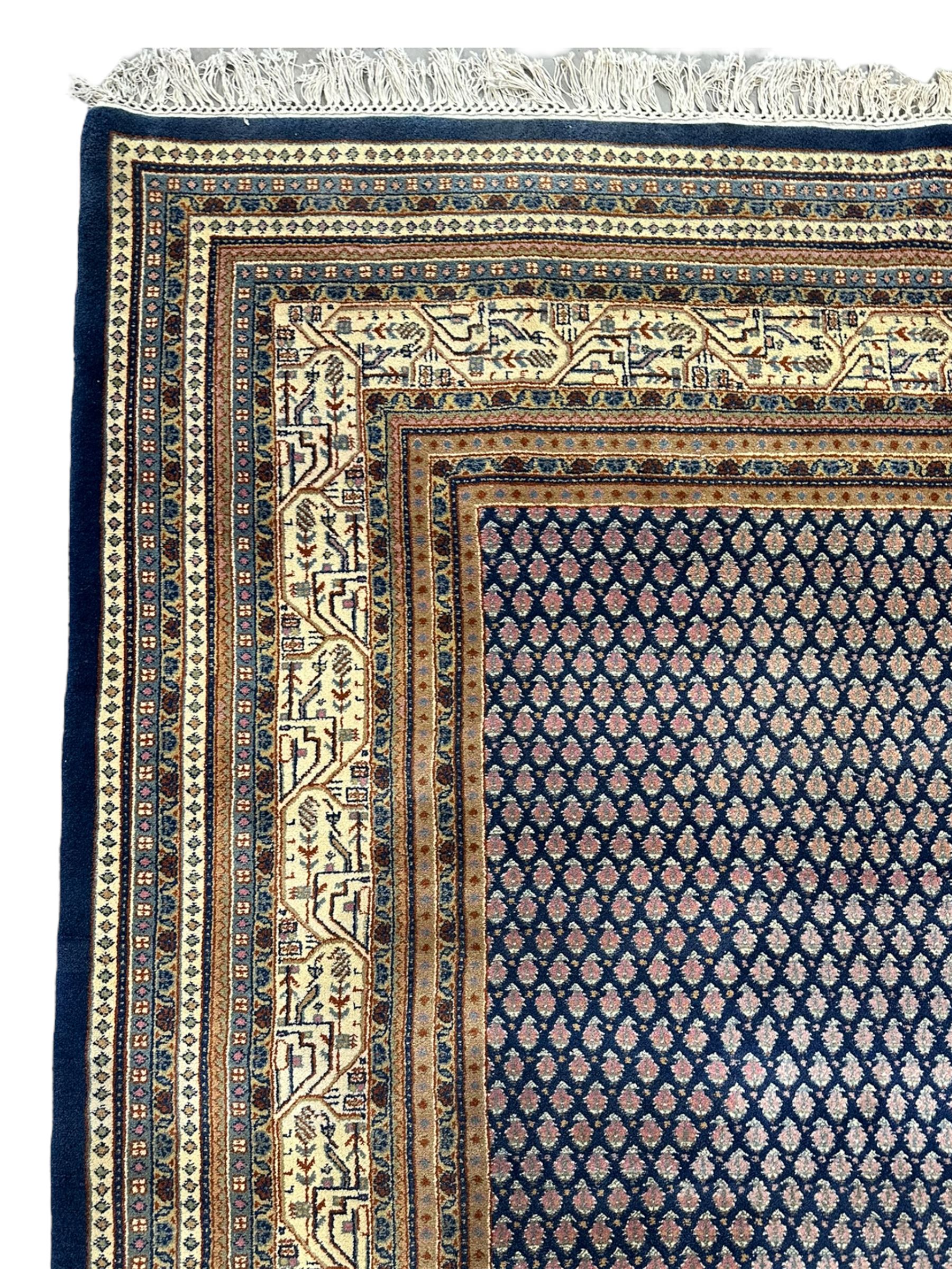 Large North-West Persian Arrak indigo ground carpet, the field decorated all-over with small Boteh motifs, multiple band border decorated with repeating geometric designs 