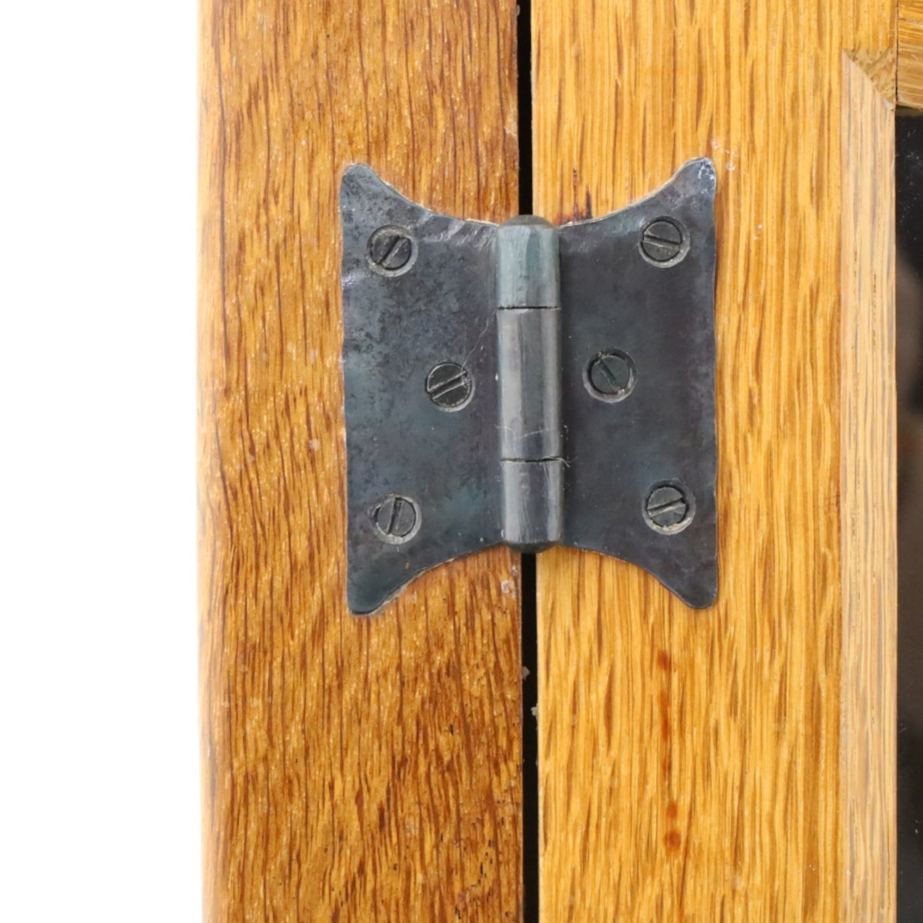 Rabbitman - oak glazed bookcase or display cabinet, lightly adzed rectangular top with raised gallery, twin glazed doors enclosing two shelves, over a pair of panelled cabinet doors with wrought iron fittings, with carved rabbit signature, by Peter Heap of Wetwang