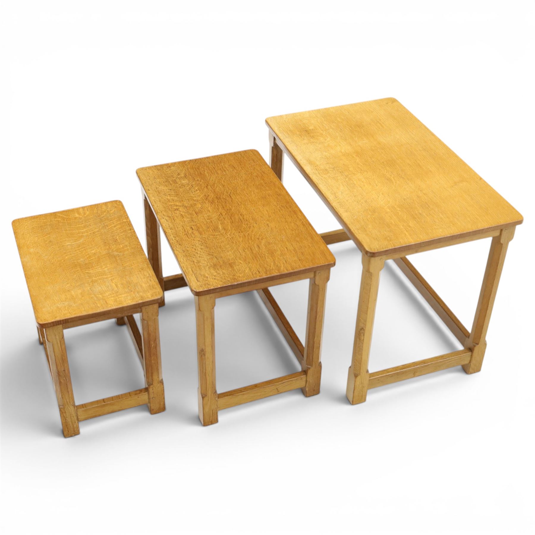 Mouseman - set of three adzed light oak nesting tables, each with rectangular top raised on octagonal legs joined by stretchers, with signature carved mouse, by the workshop of Robert Thompson, Kilburn