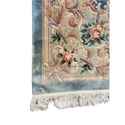 Large Chinese blue ground woollen carpet, overall floral design, central oval medallion surrounded by scrolling floral decoration, wide border with decorated with floral bouquets 