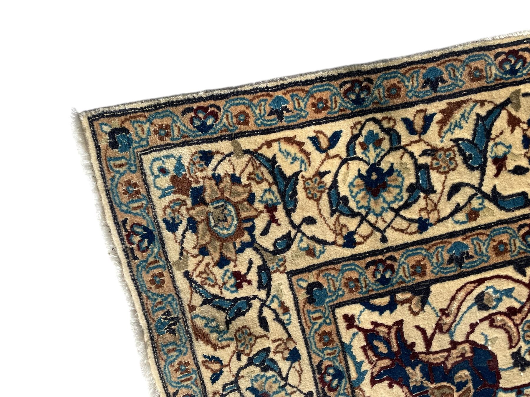 Persian Kashan ivory ground rug, wool with silk inlay, central floral rosette medallion surrounded by trailing flower heads and interlacing leafy branches, the repeating scrolling border decorated with palmettes, within guard stripes