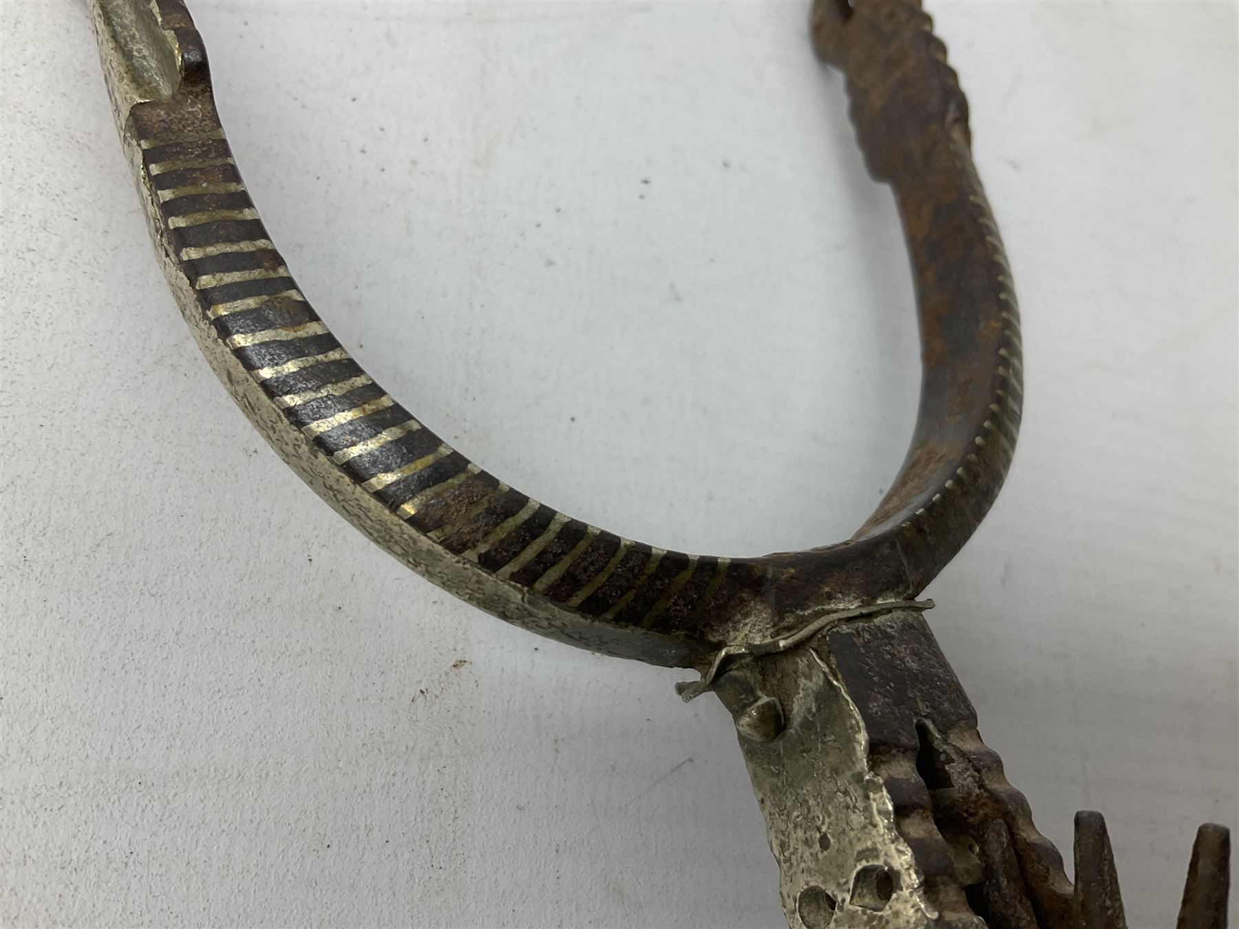 Pair of late 19th century South American iron spurs, engraved silver mounts, with sunburst rowls