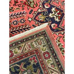 North West Persian pink ground Tabriz carpet, central indigo ground medallion surrounded by stylised plant motifs and trailing foliage, the main border with overall floral design within guard stripes 