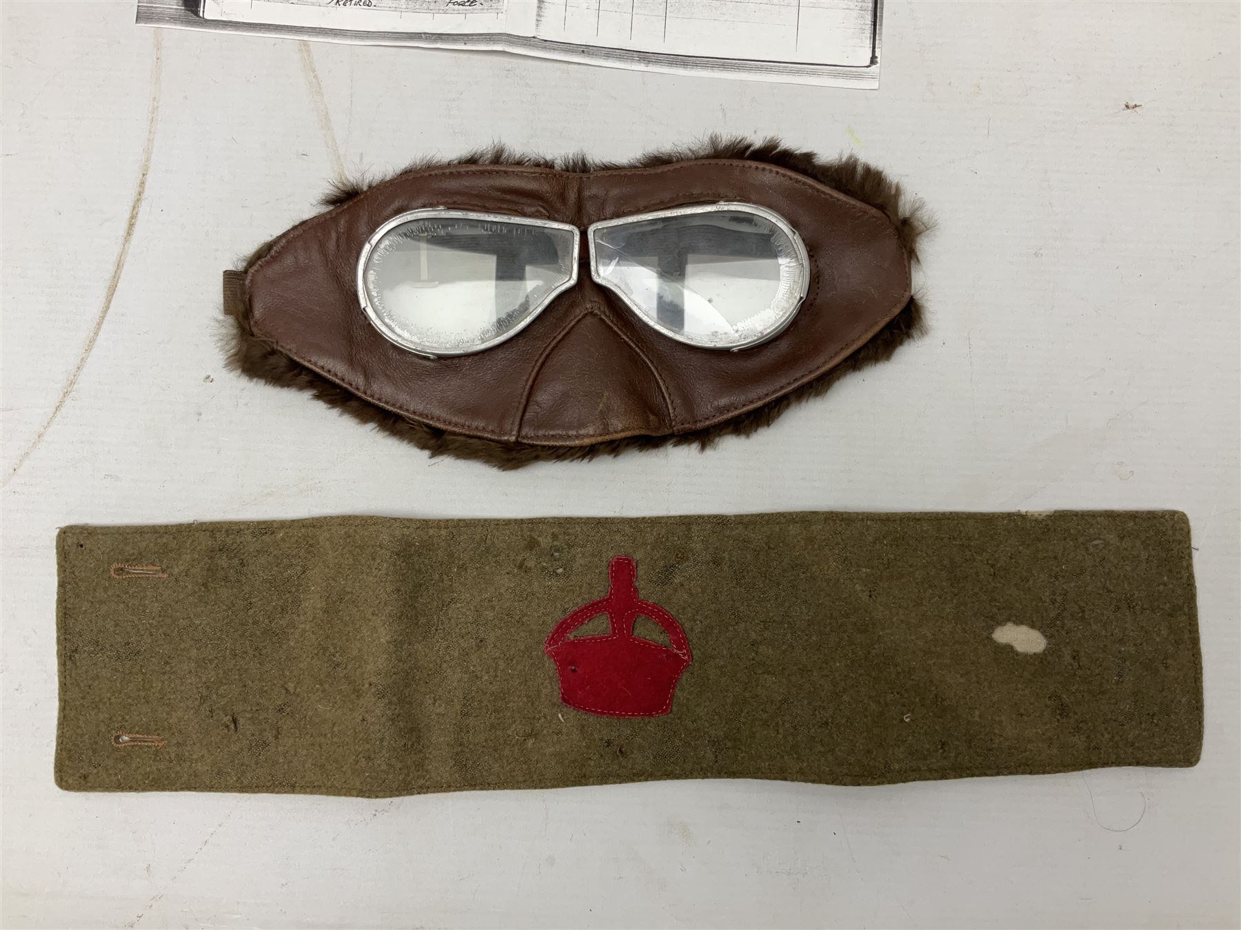 WW1 British Army Derby Scheme 1915 Attested armband; beret with East Yorkshire cap badge; pair of fur lined leather flying/motorcycle goggles; HMS Pembroke cap band; and small quantity of RNAS cloth and metal badges etc