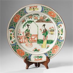 Chinese famille verte plate, painted with two ladies in a garden terrace setting, the bord...