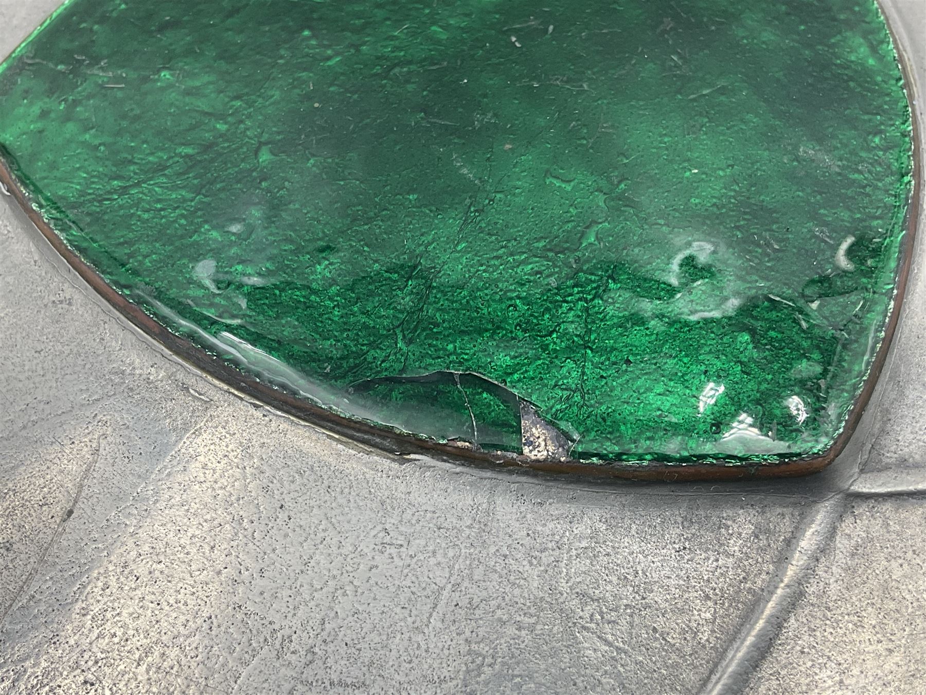 Liberty & Co Tudric pewter Bollelin tray, designed by Archibald Knox, of circular form with shaped edge, cast in relief with foliate tendrils surrounding a green enamel cartouche, impressed beneath Made by Library & Co English Pewter 044, D25.5cm